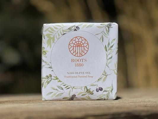 Pure olive SOAP BAR of Awaida Roots 1880 on a wooden surface with a blurred natural background